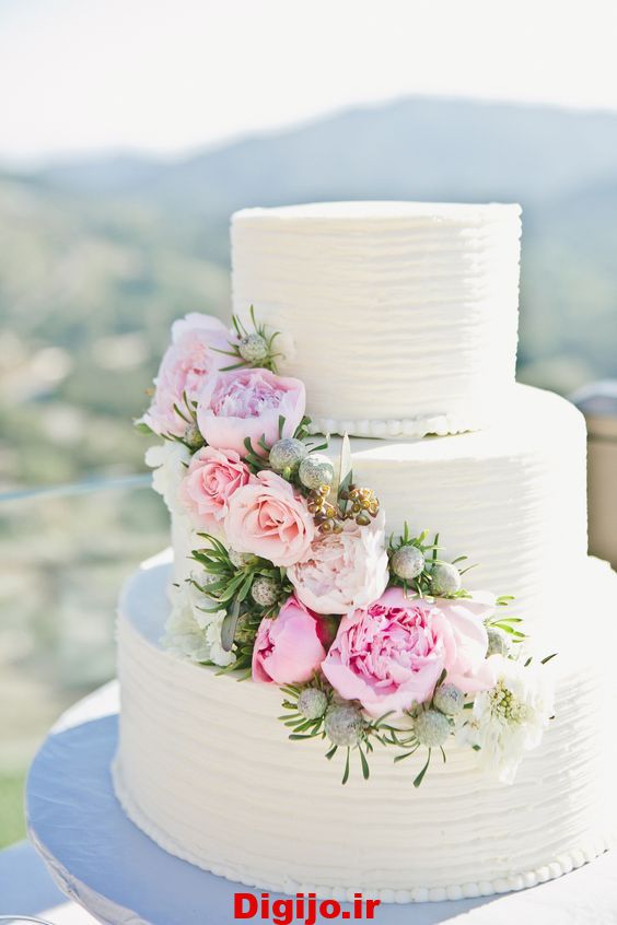 کیک عروسی سه طبقه خامه ای با تزیین گل طبیعی